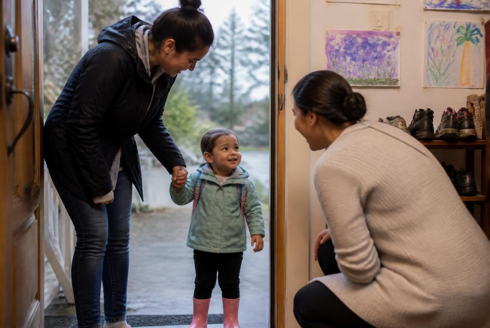 A parent and toddler being welcomed into a family home daycare